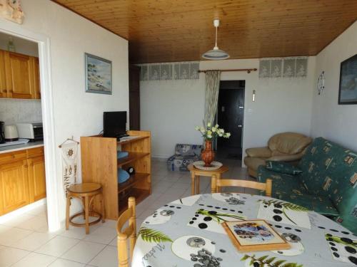 Il dispose d'une cuisine et d'un salon avec une table et un canapé. dans l'établissement STUDIO BELLE VUE SUR MER, à Saint-Jean-de-Monts