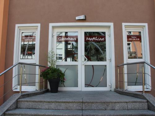 a door to a store with a plant in front at Apartments und Zimmer Gästehaus Matthias in Dresden