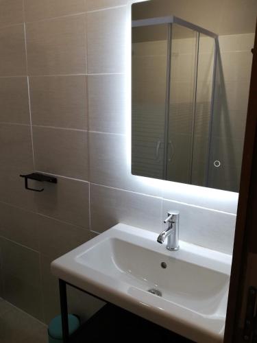 une salle de bain avec un lavabo blanc et un miroir dans l'établissement Gites en Cevennes 