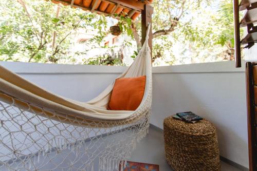 a hammock on a balcony with a window at Jeri Pousada in Jericoacoara