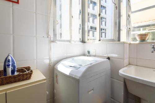 uma lavandaria branca com uma máquina de lavar roupa e um lavatório em Ponto chave no Leblon - 50m da praia - GU301 Z1 no Rio de Janeiro