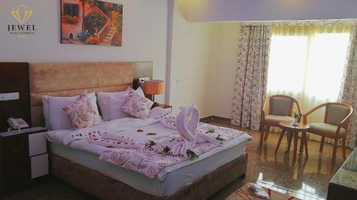 a bedroom with a large bed with pink sheets at Jewel Matrouh Hotel in Marsa Matruh