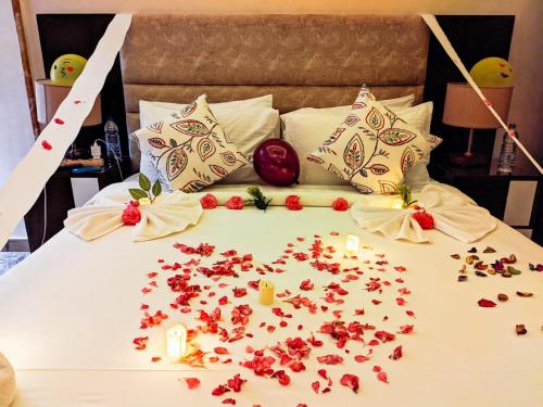 a bed with flowers on it with candles on it at Jewel Matrouh Hotel in Marsa Matruh