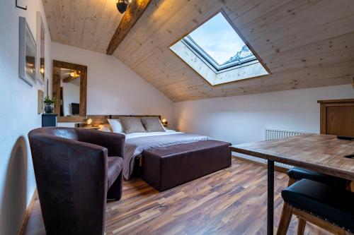Schlafzimmer mit einem Bett, einem Tisch und einem Fenster in der Unterkunft B&B Restaurant Le Pernollet in Evionnaz