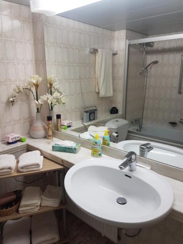 a bathroom with a sink and a bath tub at Appartementresidenz am Kurpark Bad Salzuflen in Bad Salzuflen