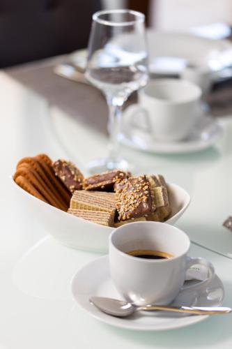 a table with a plate of pastries and a cup of coffee at Villa Grandioza in Seline