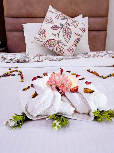 a towel on a bed with a flower on it at Jewel Matrouh Hotel in Marsa Matruh