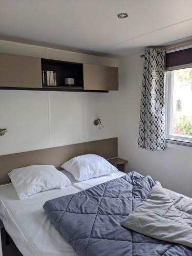 - une chambre avec un lit avec deux oreillers et une fenêtre dans l'établissement Bungalow confortable à Saint-Julien-en-Born avec piscine partagée, à Saint-Julien-en-Born