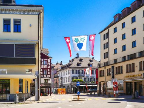 a city street with flags hanging from buildings at Lakeside Apartments Rorschach - easy self check-in in Rorschach