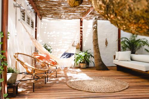 a porch with a hammock and a couch and trees at Jeri Pousada in Jericoacoara