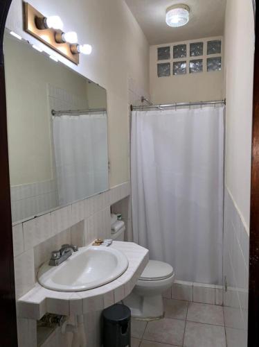 a bathroom with a sink and a toilet and a mirror at Hotel Posada San Miguel in Antigua Guatemala