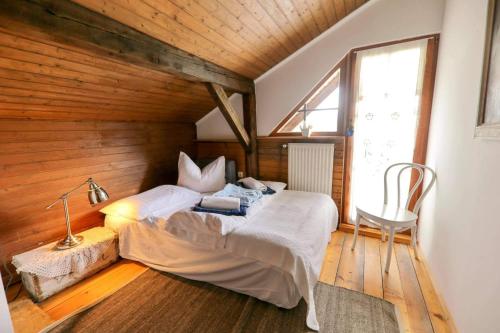 ein Schlafzimmer mit einem Bett in einem Zimmer mit Holzwänden in der Unterkunft Lake House with a View in Šmartno v Rožni Dolini