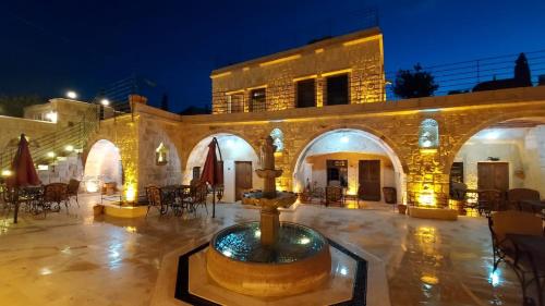 a fountain in front of a building at night at Pegas Cave Suites in Urgup