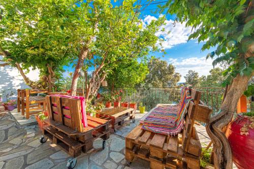 a group of chairs sitting on a patio with trees at Katerina Fotopoulos Rooms & Apartments - Papanero com in Agios Ioannis Pelio