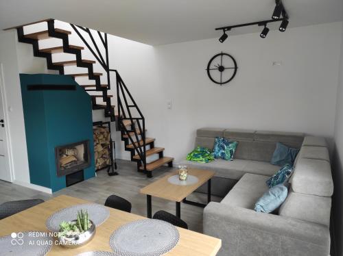 a living room with a couch and a spiral staircase at Domek Kaszuby Stężyca z banią i sauną in Stężyca