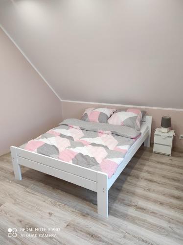 ein weißes Bett in einem Zimmer mit einer weißen Wand in der Unterkunft Domek Kaszuby Stężyca z banią i sauną in Stężyca