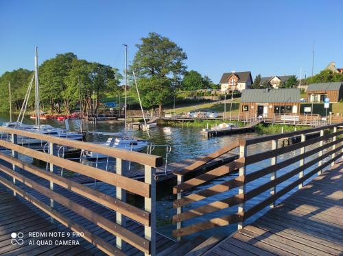 a wooden dock with boats in a marina at Domek Kaszuby Stężyca z banią i sauną in Stężyca