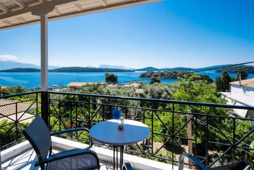 a balcony with a table and chairs and a view of the water at Spiros Sea View in Nydri