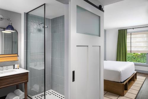 a bath room with a shower and a tub at Wylie Hotel in Atlanta
