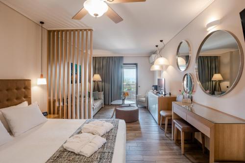 a bedroom with a bed and a living room at Akti Taygetos - Conference Resort in Kalamata