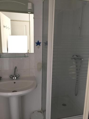 une salle de bain avec un lavabo et une douche dans l'établissement Les Balcons de la Mer, à Valras-Plage