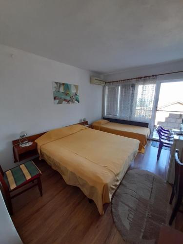 a bedroom with two beds and a window at Villa Trakia in Golden Sands