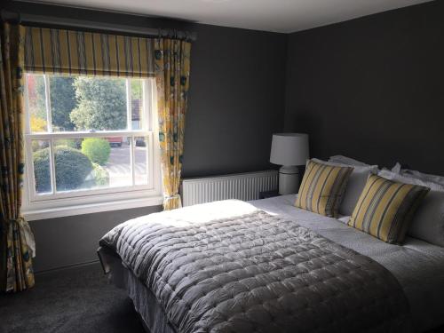 ein Schlafzimmer mit einem großen Bett und einem Fenster in der Unterkunft Cosy Lincs Wolds cottage in picturesque Tealby in Tealby