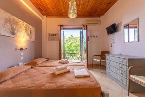 a bedroom with two beds and a dresser and a window at Katerina Fotopoulos Rooms & Apartments - Papanero com in Agios Ioannis Pelio