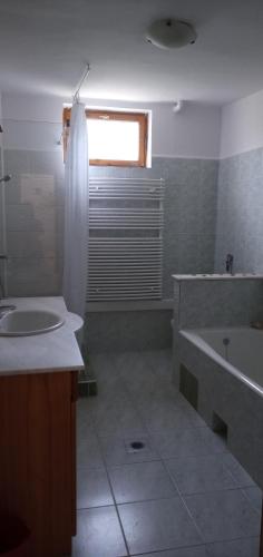a bathroom with a tub and a sink and a bath tub at Emma vendégház in Sárospatak