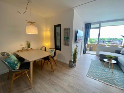 ein Wohnzimmer mit Tisch und Couch in der Unterkunft Stylische Ferienwohnung TOP LAGE am Hafen, Strand und Meer in Wendtorf