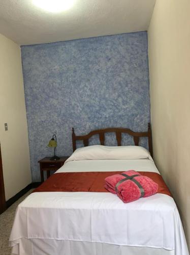 a bedroom with a bed with a blue wall at Hotel Posada San Miguel in Antigua Guatemala
