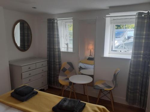 1 dormitorio con 1 cama, mesa y sillas en THE BOTHY SUITE BY TEMPLE WOOD, en Lochgilphead