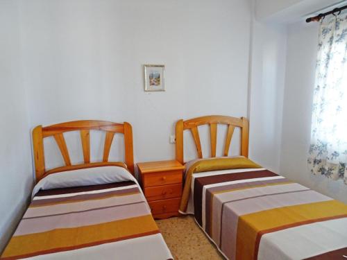 two beds in a room with white walls at BONAIRE - PRIMERA LÍNEA DE PLAYA in Playa de Gandia