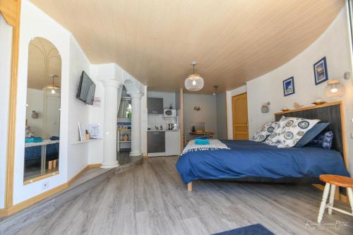 a bedroom with a blue bed and a kitchen at CASA UPUPA in Montreuil