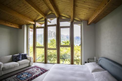 sypialnia z łóżkiem i dużym oknem w obiekcie IseoLakeRental - Villa Dossello w mieście Solto Collina