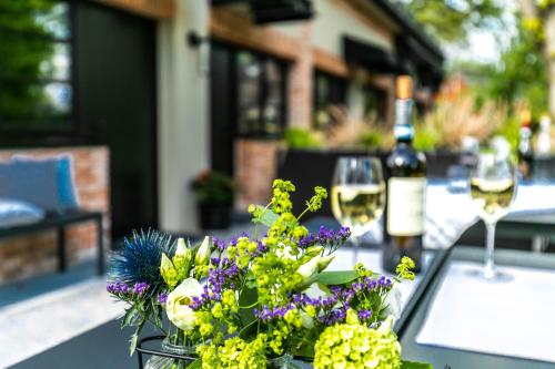 a table with a vase of flowers and wine glasses at The Roebbek x Hanse in Hamburg