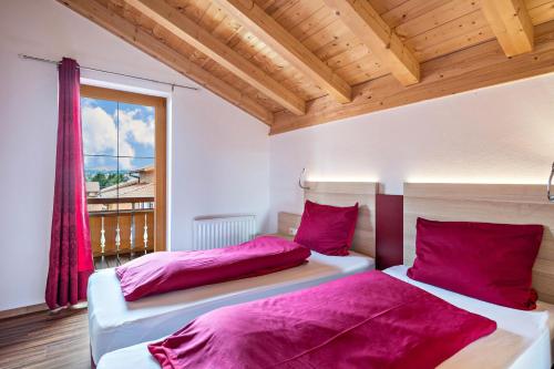 2 Betten in einem Zimmer mit Fenster in der Unterkunft Casa Romantica in Lechbruck