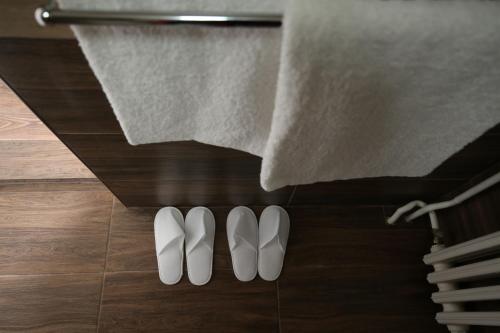 a pair of white shoes on the floor next to a towel at Apartments & Dream Rooms in Niš
