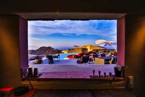 a window view of a patio with a view of the desert at White Pearl Cavalieri in Imerovigli