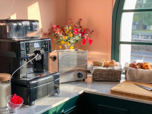 a kitchen with a counter with a coffee maker and bread at Grand Hôtel Saint-Aignan in Saint-Aignan