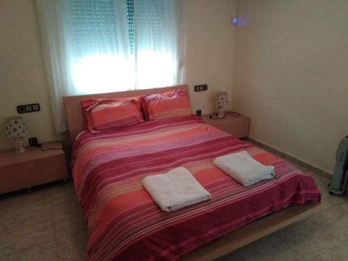 een slaapkamer met een groot bed en 2 handdoeken bij Estrella Del Mar Tranquil and spacious villa, convenient location 3-5 mins' walk to all amenities in Villacosta