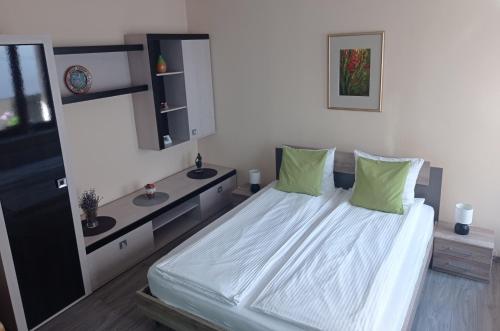 a bedroom with a large bed with green pillows at Citadel Residence in Sighişoara