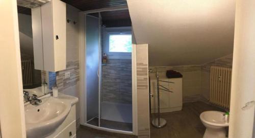 a bathroom with a shower and a toilet and a sink at Appartamento la mansarda in Lecco
