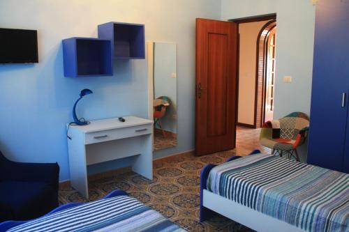 a bedroom with two beds and a desk and a mirror at Casa Vacanze Ramo in Mazara del Vallo