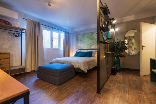 a bedroom with a bed and a ottoman in a room at MenzaTesta - Casa indipendente con terrazzo in Ragusa