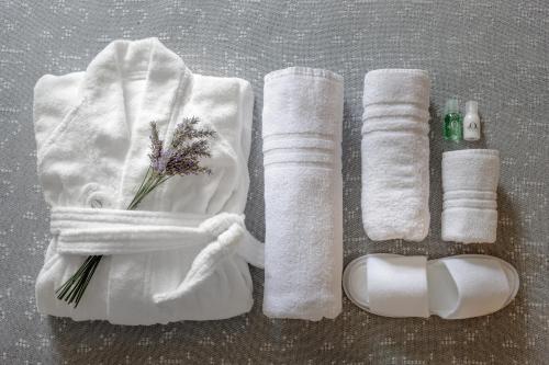 uma toalha branca e toalhas com flores e cosméticos em Euro Hotel em Nuoro