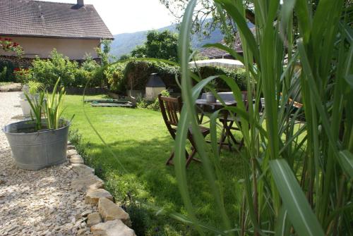 a garden with a bench and a table in the grass at Carpe Diem - Bnb - Chambres d'hôtes in Péry