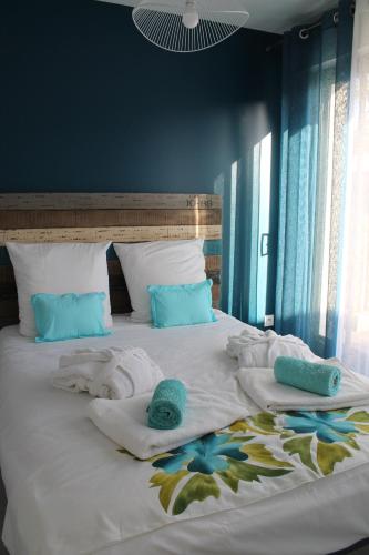 - un grand lit avec des serviettes et des oreillers dans l'établissement MAGNIFIQUES APPTS à 1 MINUTE DE LA PLAGE, à Andernos-les-Bains