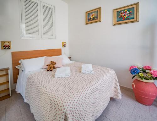 um urso de peluche sentado numa cama num quarto em Nonna Rosetta Traditional Studio em Vernazza