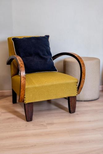 a yellow chair with a blue pillow in a room at Albergo Cerchi in Tortona